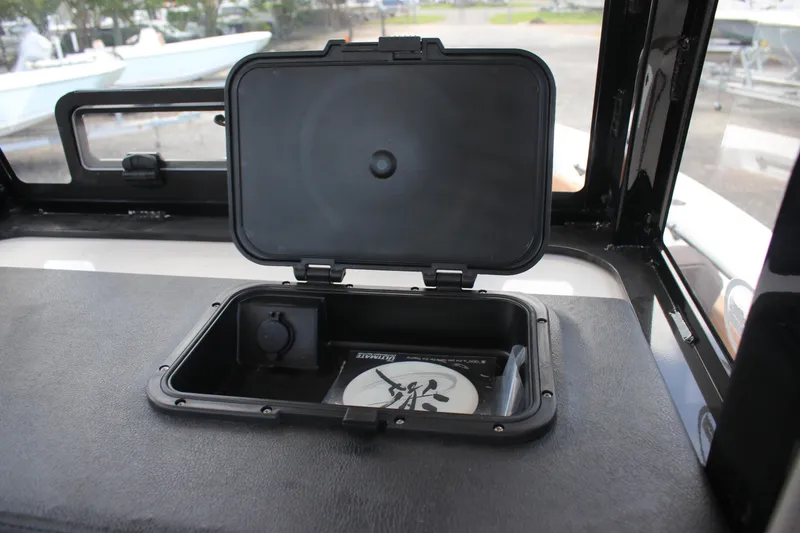 Slide: The Image of Open storage compartment on 2025 Sea Pro 245 FLX boat dashboard. - 22