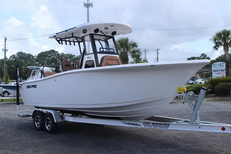 Slide: The Image of 2025 Sea Pro 245 FLX boat on trailer, parked outdoors, showcasing sleek design and modern features. - 5