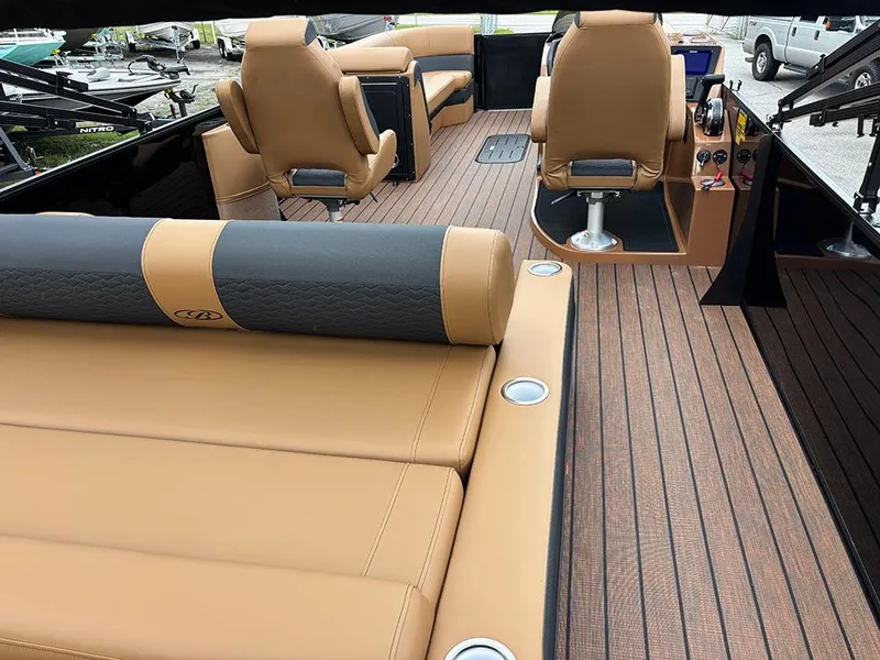 Slide: The Image of 2025 Bentley Pontoons Elite 253 interior with tan seating and wood-style flooring. - 10