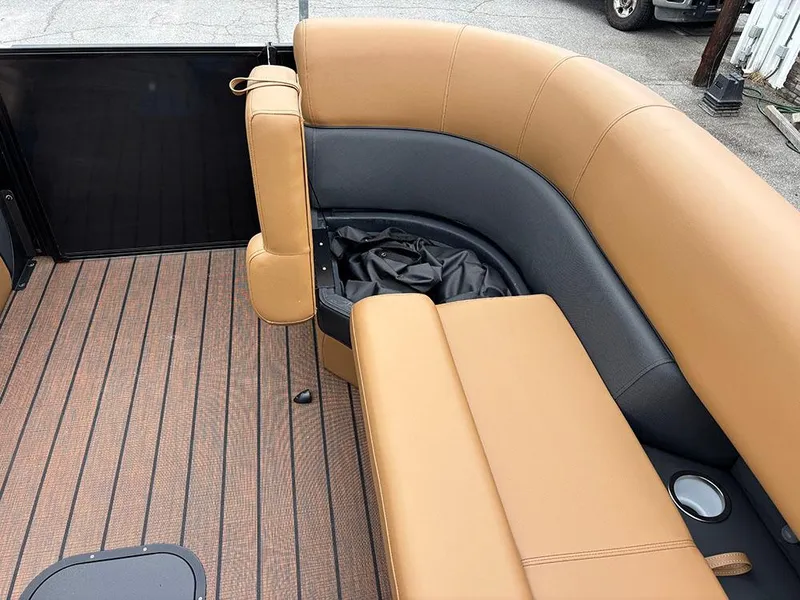 Slide: The Image of 2025 Bentley Pontoons Elite 253 interior with tan and black seating, wood-style flooring. - 17