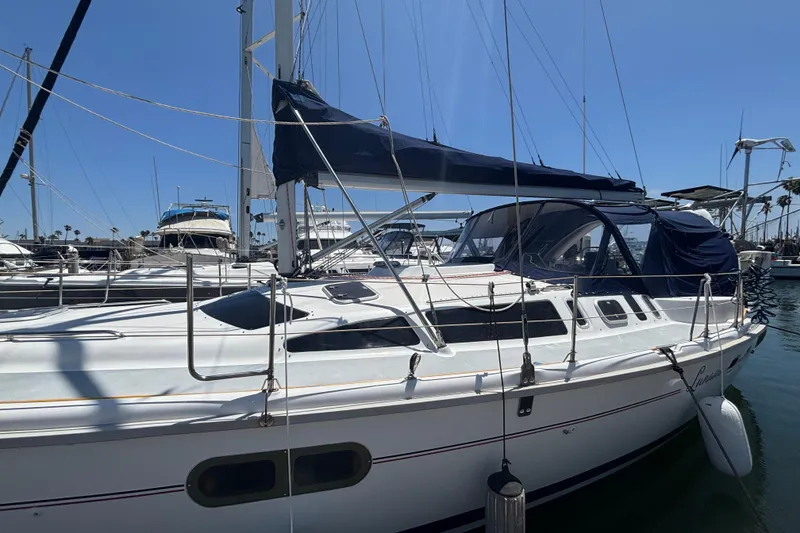 Slide: The Image of Sailboat docked in marina, 1999 Hunter 410 model, with blue canopy and clear skies. - 11