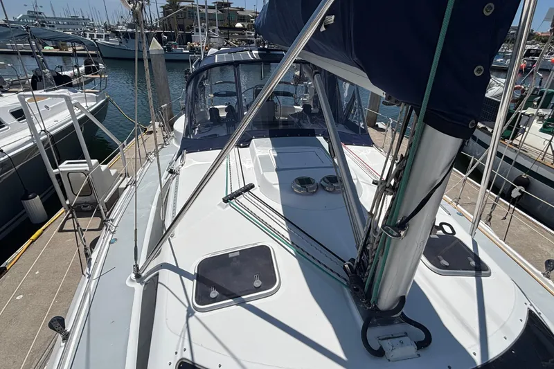 Slide: The Image of 1999 Hunter 410 sailboat docked at marina, showcasing deck and rigging. - 15