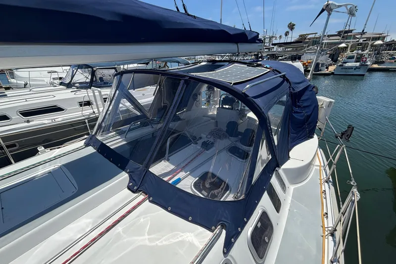 Slide: The Image of 1999 Hunter 410 sailboat with blue canopy docked at marina. - 17