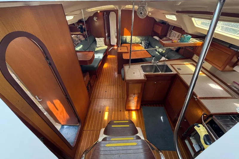 Slide: The Image of Interior of 1999 Hunter 410 sailboat with wood finish and cozy seating area. - 32