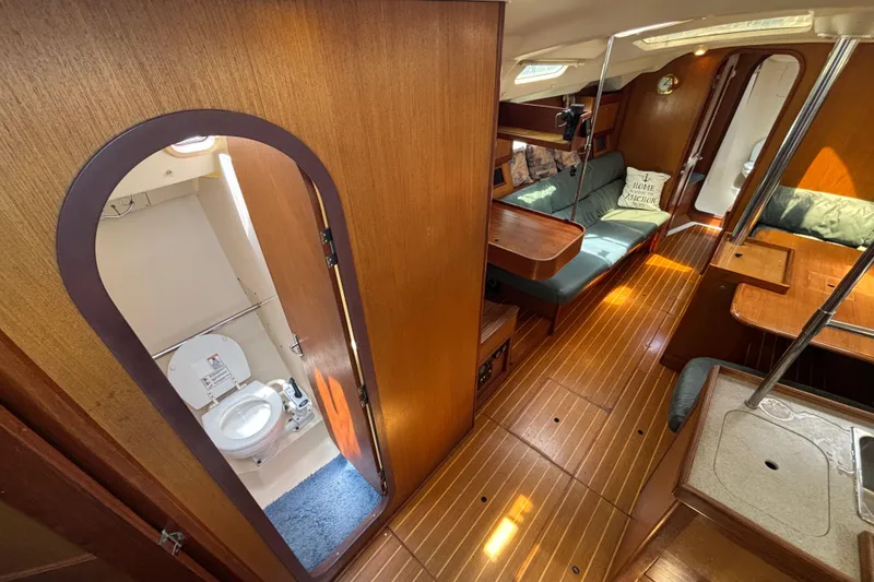 Slide: The Image of Interior of a 1999 Hunter 410 sailboat featuring a cozy cabin and compact bathroom. - 33