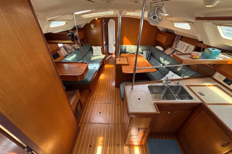 Slide: The Image of Interior of a 1999 Hunter 410 sailboat with wood finish and cozy seating area. - 34