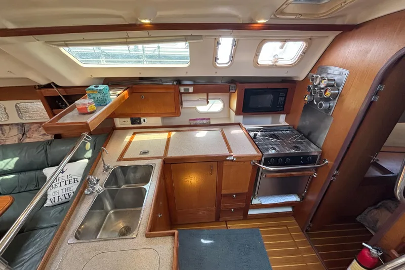 Slide: The Image of Interior of a 1999 Hunter 410 sailboat kitchen with stove, sink, and microwave. - 38