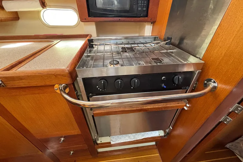 Slide: The Image of 1999 Hunter 410 yacht kitchen with stove, oven, and microwave in wooden cabinetry. - 41