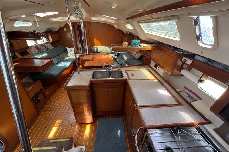 Slide: The Image of Interior of a 1999 Hunter 410 sailboat with wood finishes and cozy seating area. - 42