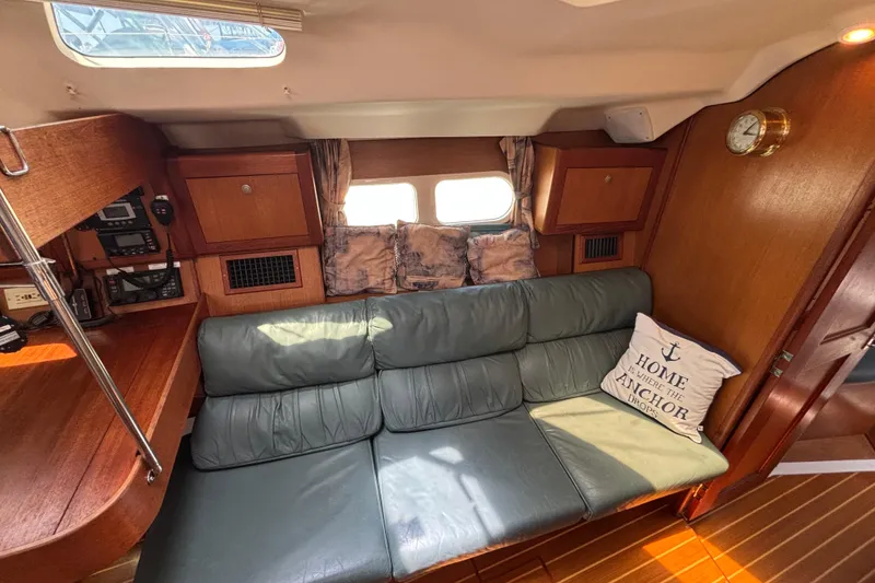 Slide: The Image of Cozy interior of 1999 Hunter 410 sailboat with green sofa and nautical decor. - 45