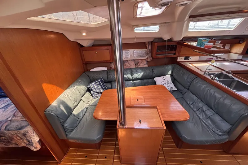 Slide: The Image of Cozy interior of 1999 Hunter 410 sailboat with cushioned seating and wooden table. - 46