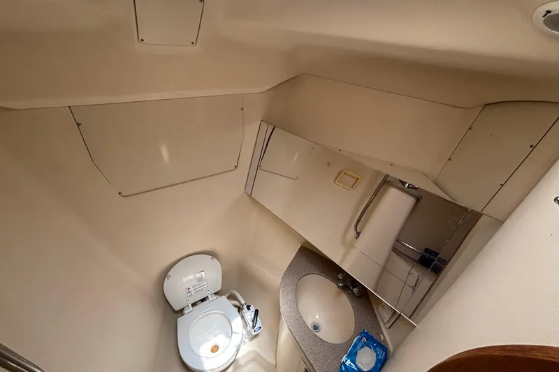 Slide: The Image of Bathroom interior of a 1999 Hunter 410 yacht, featuring a toilet and sink. - 51