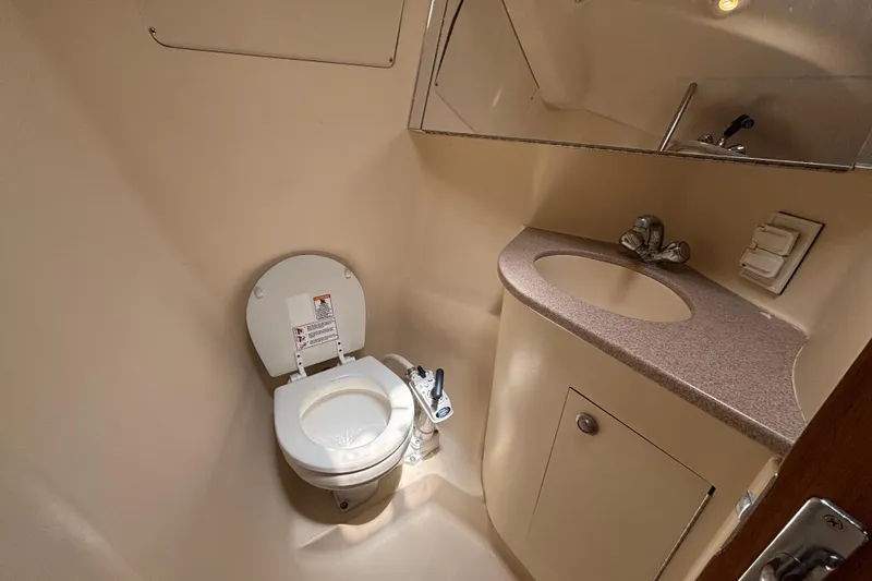 Slide: The Image of 1999 Hunter 410 yacht bathroom with toilet, sink, and mirror. - 53