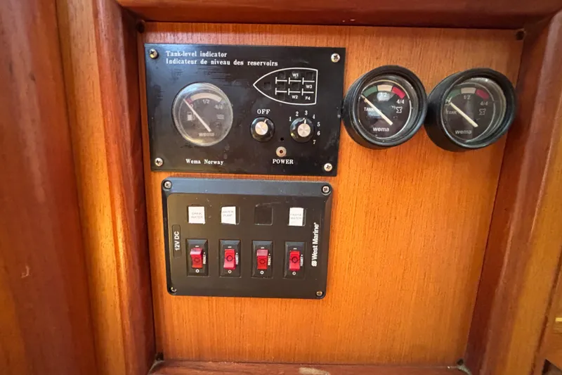 Slide: The Image of Control panel of a 1999 Hunter 410 boat with gauges and switches. - 54