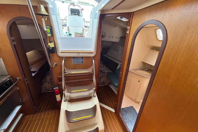 Slide: The Image of Interior of 1999 Hunter 410 sailboat with wooden finish and compact living space. - 56
