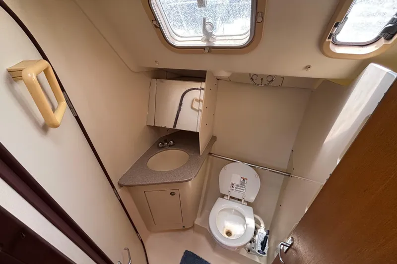 Slide: The Image of Compact bathroom in a 1999 Hunter 410 sailboat with toilet, sink, and storage. - 57