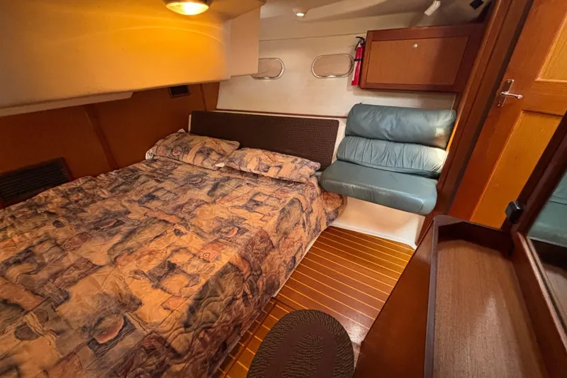 Slide: The Image of Cozy cabin interior of 1999 Hunter 410 sailboat with patterned bedding and wooden accents. - 61