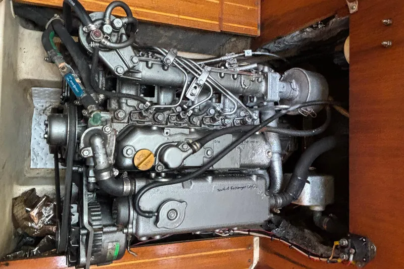 Slide: The Image of Engine of a 1999 Hunter 410 sailboat, showcasing mechanical components and hoses. - 63