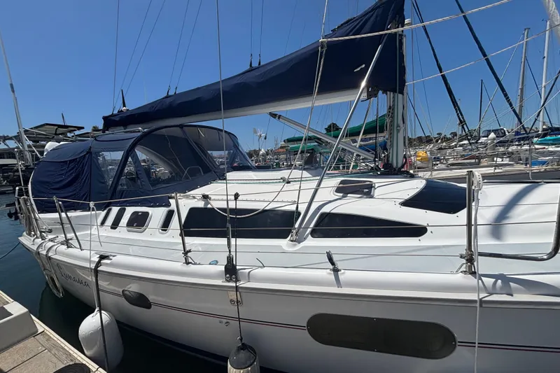 Slide: The Image of Sailboat Hunter 410, 1999 model, docked at marina with blue canopy. - 9
