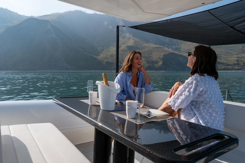 Slide: The Image of Two people enjoying a conversation on a 2025 Anvera 42 yacht, with scenic mountain views. - 10