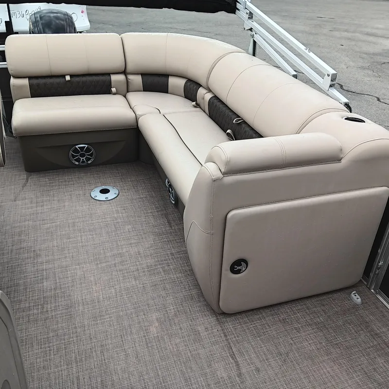 Slide: The Image of 2025 Sun Tracker Party Barge 20 DLX with beige seating and carpeted deck. - 11