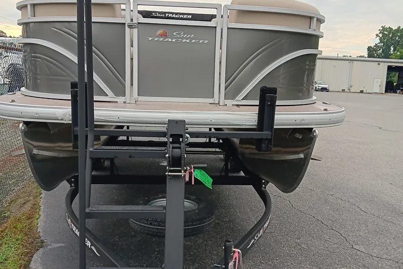Slide: The Image of 2025 Sun Tracker Party Barge 20 DLX pontoon boat on trailer, parked outdoors. - 4