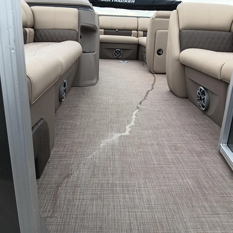 Slide: The Image of 2025 Sun Tracker Party Barge 20 DLX interior with beige seating and carpet flooring. - 5