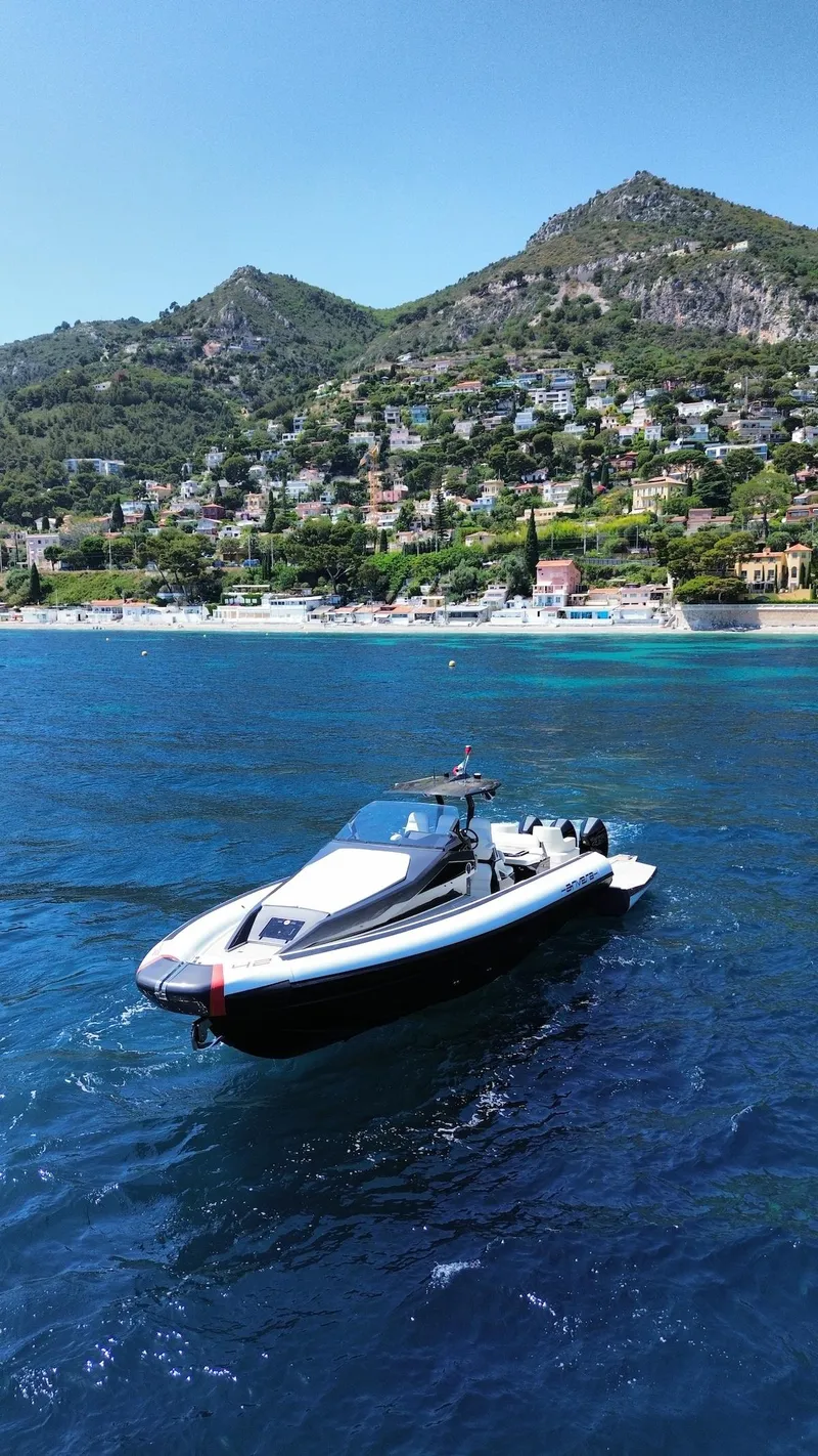Slide: The Image of 2025 Anvera 42 Speedster boat on scenic coastal waters with mountainous backdrop. - 10