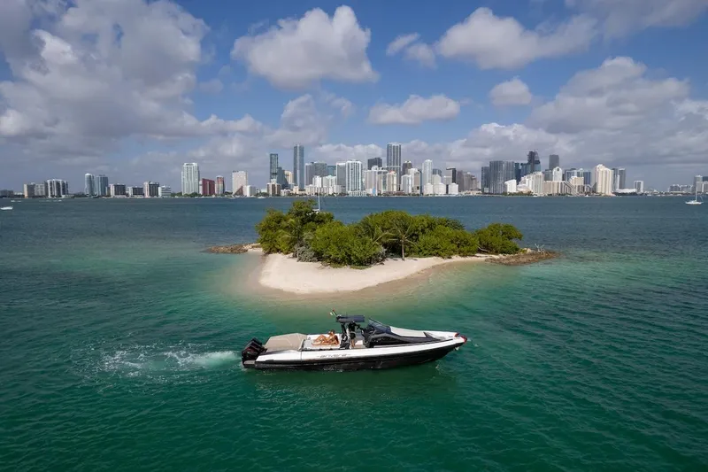 Slide: The Image of 2025 Anvera 42 Speedster cruising near a small island with city skyline backdrop. - 20