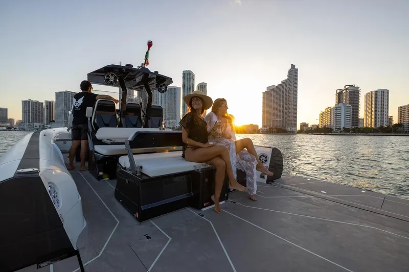 Slide: The Image of 2025 Anvera 42 Speedster boat cruising with passengers at sunset near city skyline. - 7