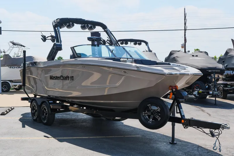 Slide: The Image of 2025 MasterCraft XT24 boat on trailer in parking lot. - 13