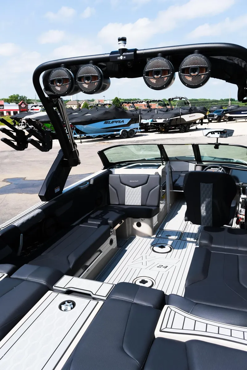 Slide: The Image of 2025 MasterCraft XT24 boat interior with sleek seating and advanced audio system. - 16