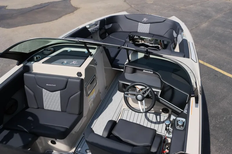Slide: The Image of 2025 MasterCraft XT24 boat interior with sleek seating and modern dashboard design. - 18