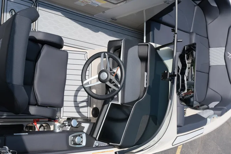 Slide: The Image of 2025 MasterCraft XT24 boat interior with steering wheel and seating. - 19
