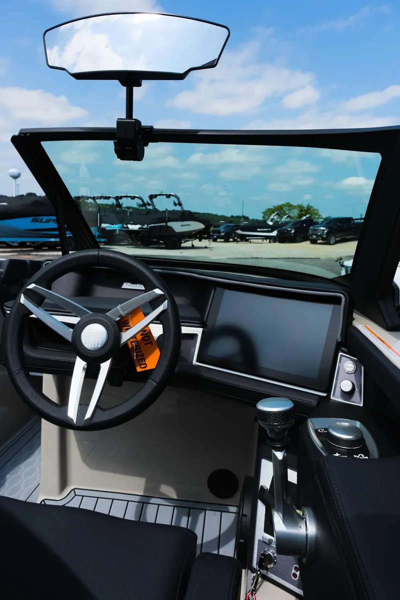 Slide: The Image of 2025 MasterCraft XT24 boat dashboard with steering wheel and touchscreen display. - 26