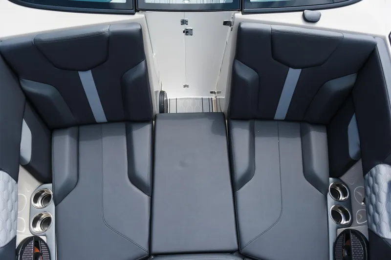 Slide: The Image of 2025 MasterCraft XT24 boat interior with sleek black seating and cup holders. - 33