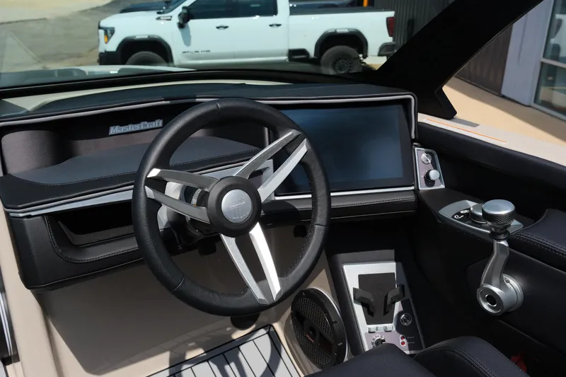 Slide: The Image of 2025 MasterCraft XT24 boat dashboard with modern steering wheel and digital display. - 36
