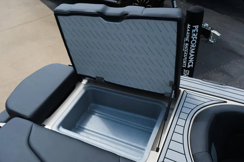 Slide: The Image of 2025 MasterCraft XT24 boat storage compartment with open lid, showcasing interior space. - 39