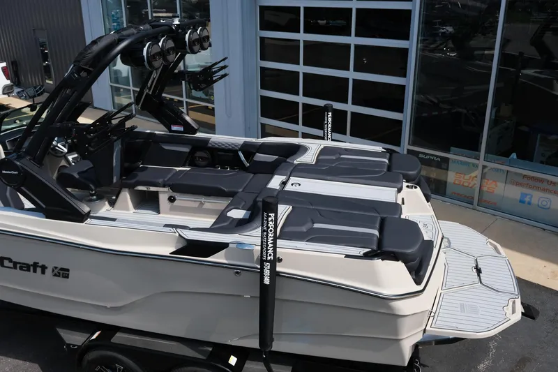 Slide: The Image of 2025 MasterCraft XT24 boat with sleek design and modern features, docked near a building. - 5