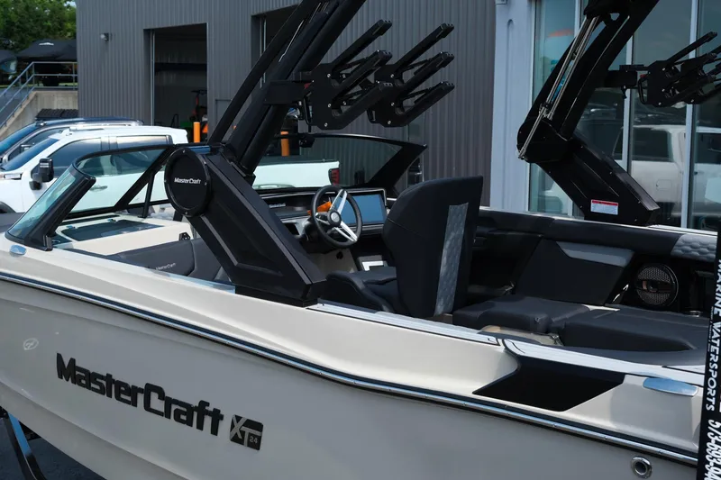 Slide: The Image of 2025 MasterCraft XT24 boat with sleek design and modern features, docked near a building. - 6