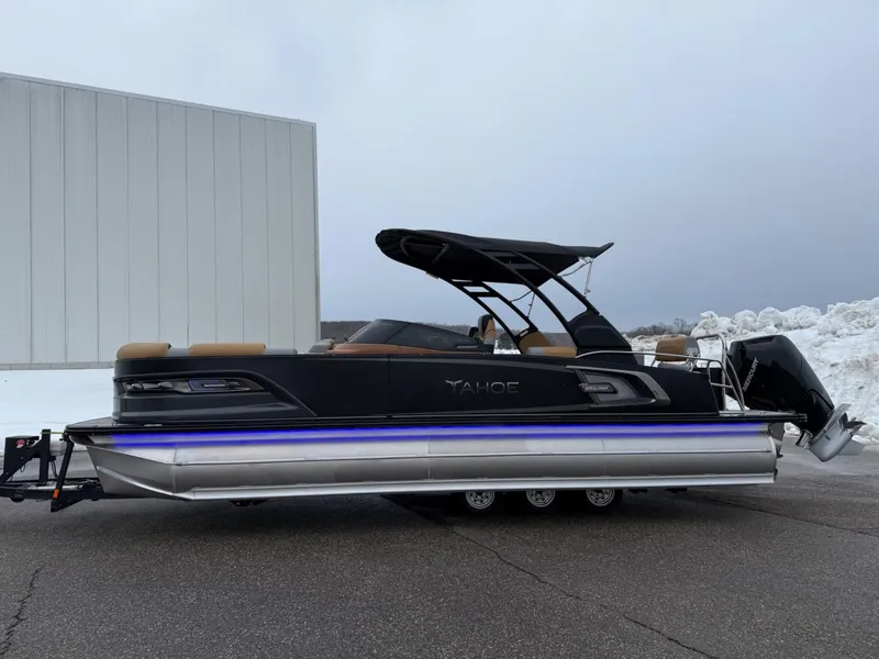 Slide: The Image of 2025 Tahoe Pontoon Grand Tahoe LTD Quad Lounge Windshield on trailer, parked outdoors. - 2