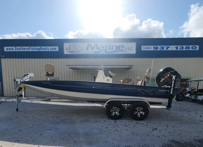 Slide: The Image of 2025 Xpress H22B boat on trailer outside L&M Marine dealership. - 0