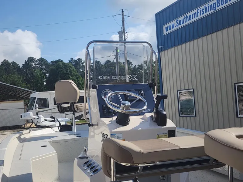 Slide: The Image of 2025 Xpress H22B boat at Southern Fishing Boats dealership, showcasing steering console and seating. - 11
