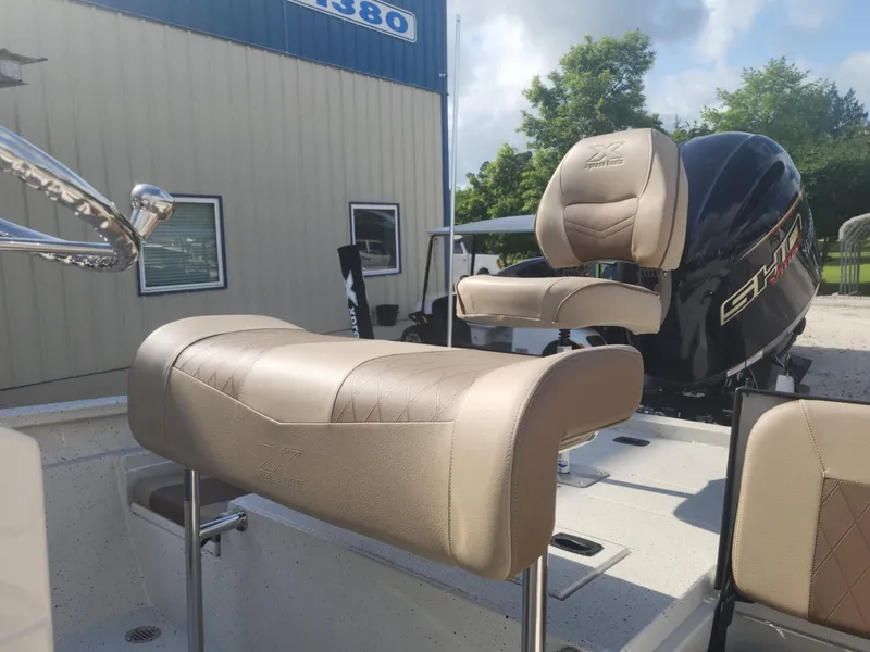 Slide: The Image of 2025 Xpress H22B boat with beige seating and powerful outboard motor. - 8