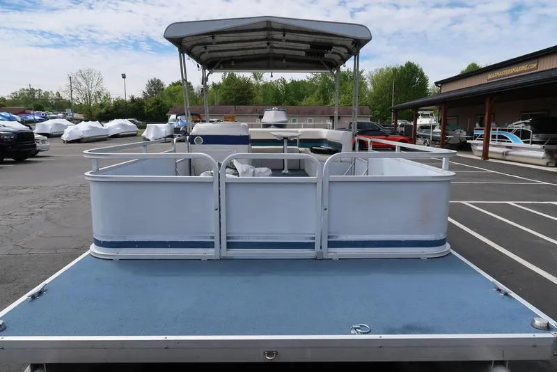 Slide: The Image of 1994 Sweetwater 2400 pontoon boat with canopy in a parking lot. - 4