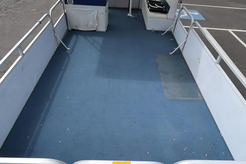 Slide: The Image of 1994 Sweetwater 2400 boat deck with blue carpet and white railings. - 6