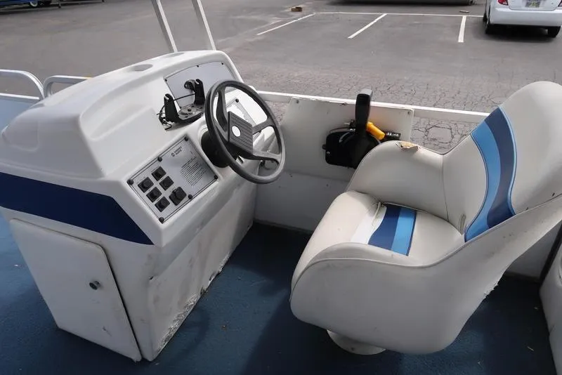 Slide: The Image of Interior of a 1994 Sweetwater 2400 boat showing steering wheel and captain's chair. - 8