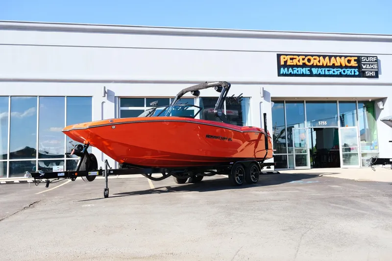 Slide: The Image of 2025 MasterCraft NXT24 boat in vibrant orange at Performance Marine Watersports dealership. - 1