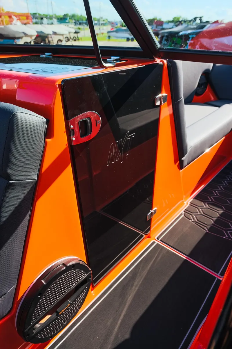 Slide: The Image of 2025 MasterCraft NXT24 interior, featuring sleek orange and black design with modern seating. - 24