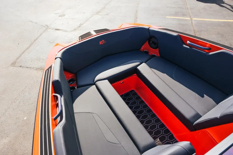 Slide: The Image of 2025 MasterCraft NXT24 boat interior with sleek seating and vibrant orange accents. - 26